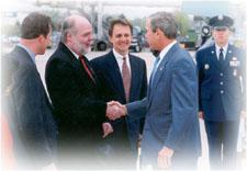 Dennis Shaw greeting President George W. Bush at steps of Air Force One. Gary Arneson is at Shaw's right and Rep. Mike Huebsch is on Shaw's left.